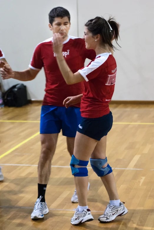 a man and woman in red are standing on a court