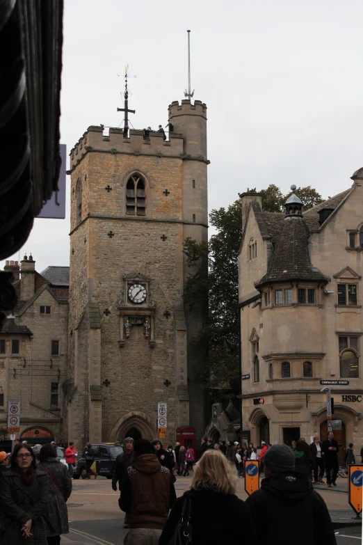 a group of people standing around a stone clock tower