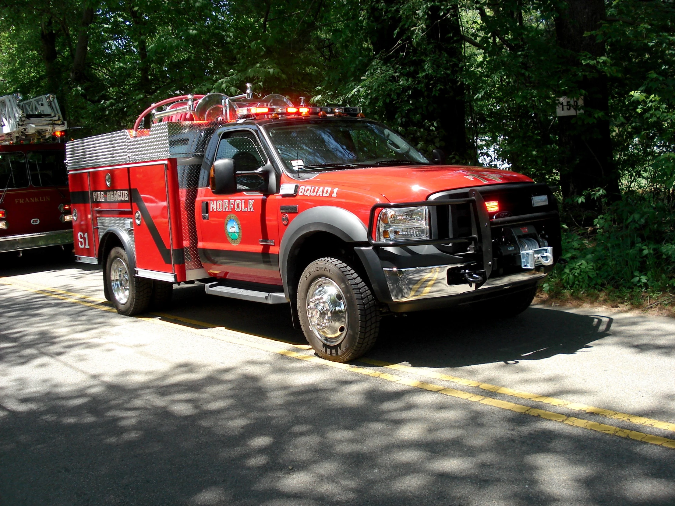 two fire trucks are parked together in the street