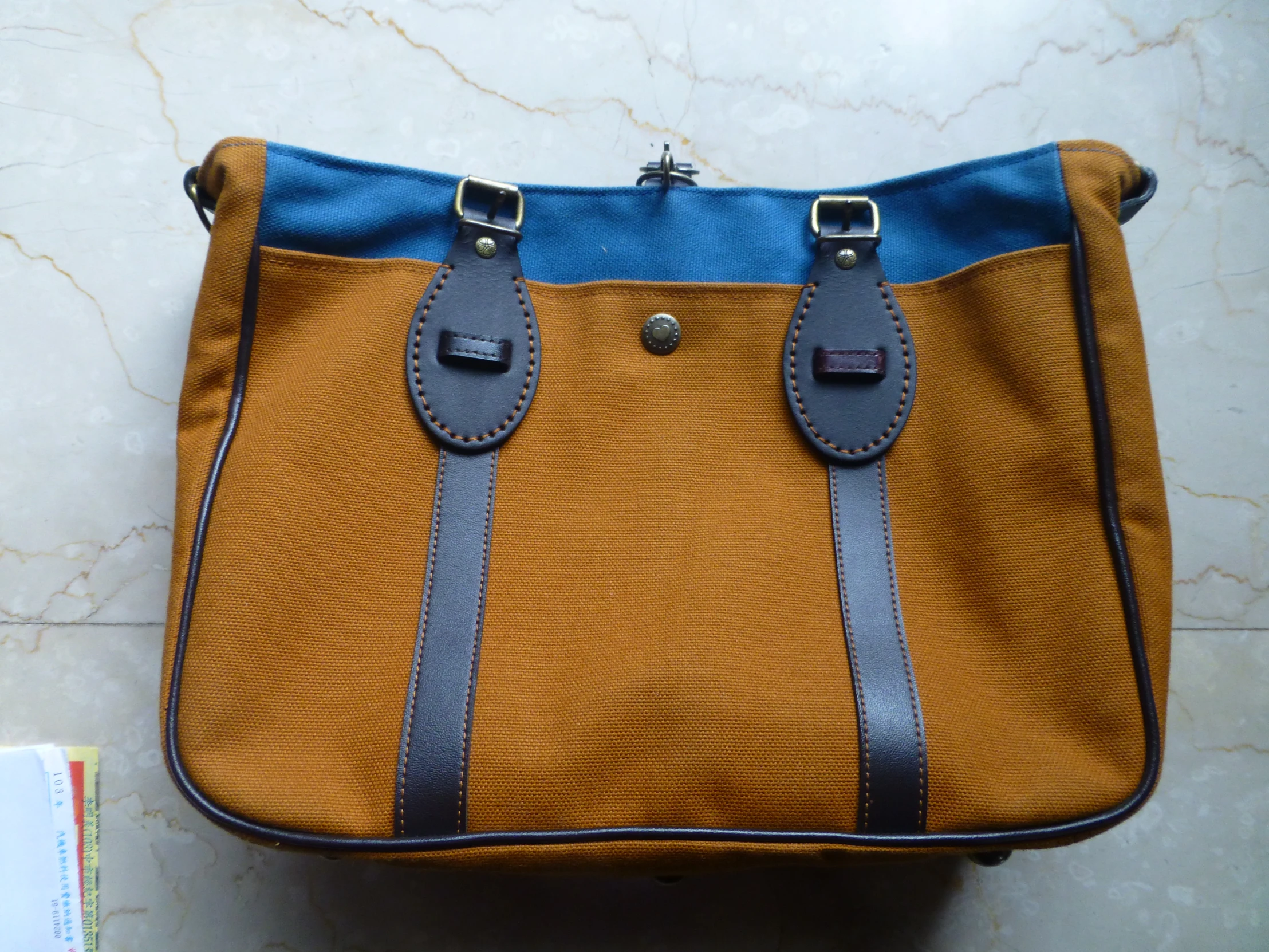 a yellow and blue purse with straps on the handles