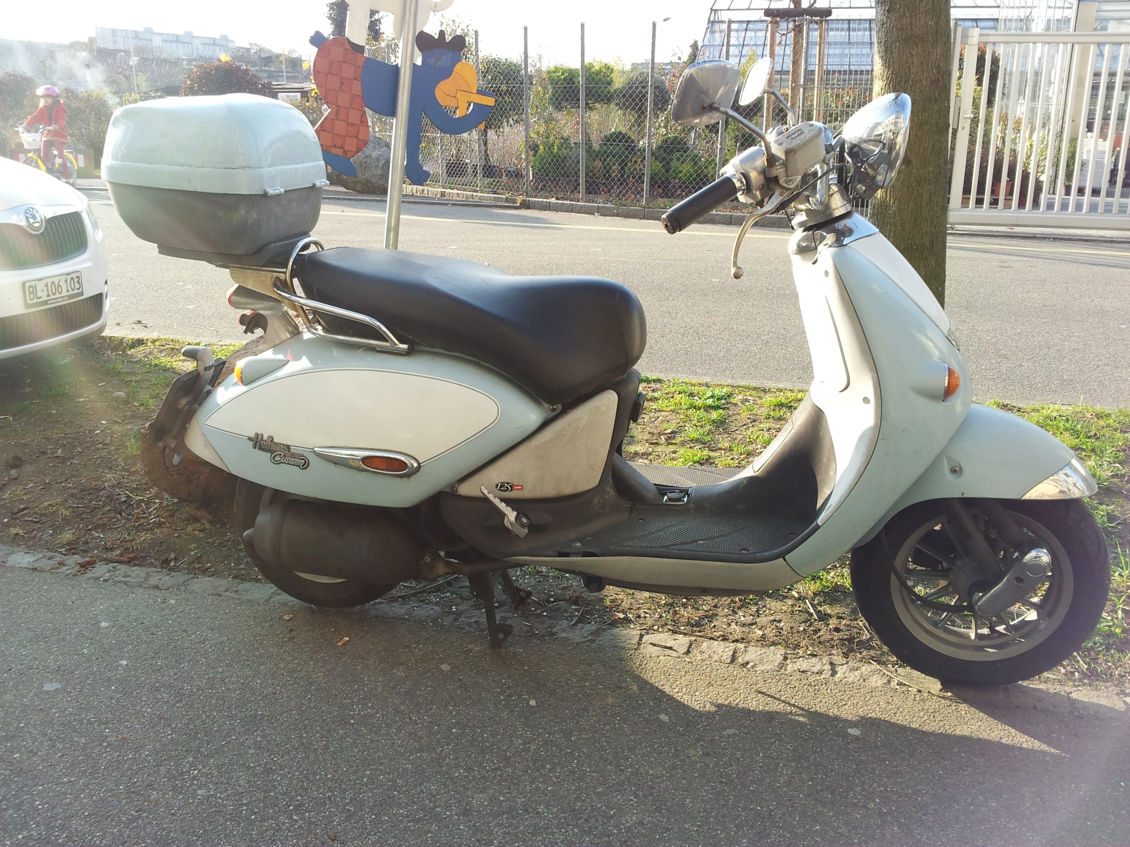 a moped is parked on the curb near the street