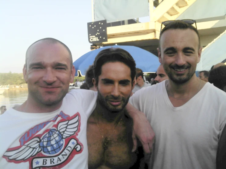 three men are standing side by side at a fair