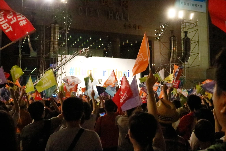 a group of people holding up flags and banners