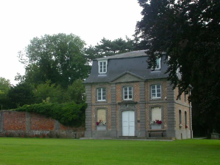 a home with two chimneys and a gate