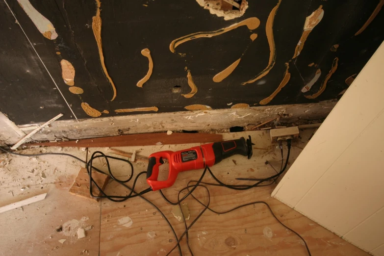 a floor with a power strip connected to a device and some wires