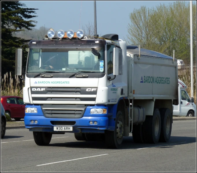 a truck driving down the road with cars on it