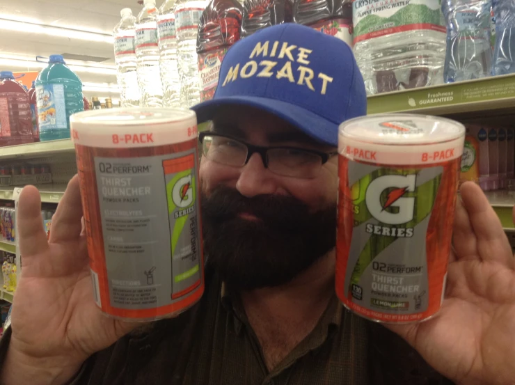 a man holding two cans of millers root beer