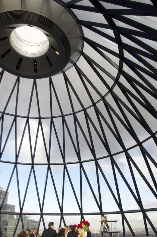 people standing under a glass dome looking at soing