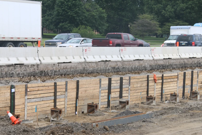 two trucks traveling down a road near construction