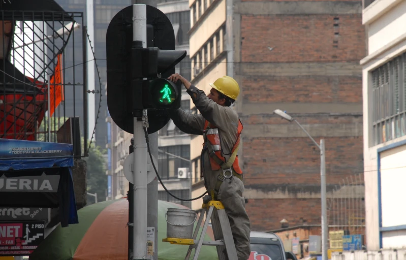 a man on the street working with a traffic light