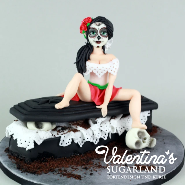 a cake that has a female skeleton sitting on top