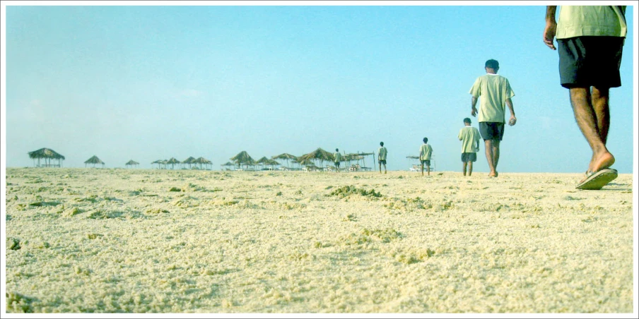 a few people standing on a beach next to each other