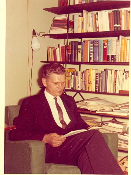 a man sitting in a chair reading a book