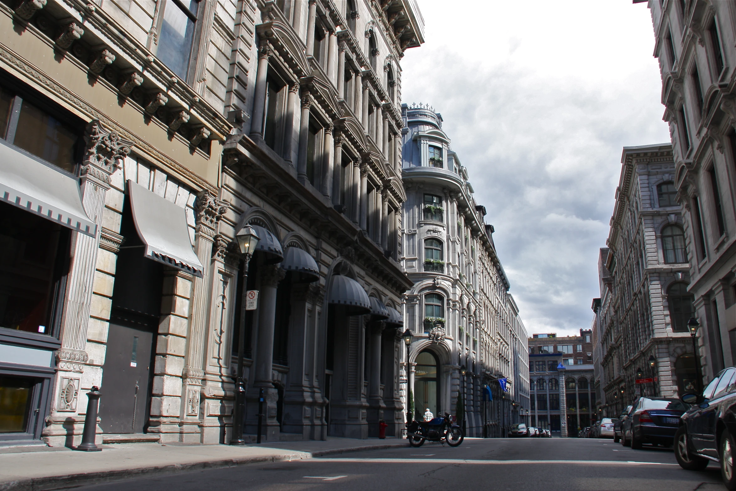 cars and motorcycles drive through an old - fashioned building