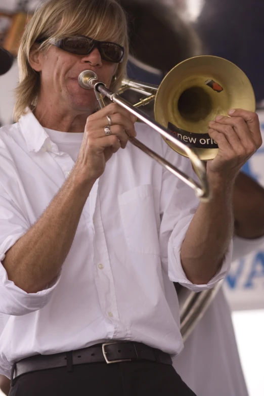 a person in white shirt playing a trumpet