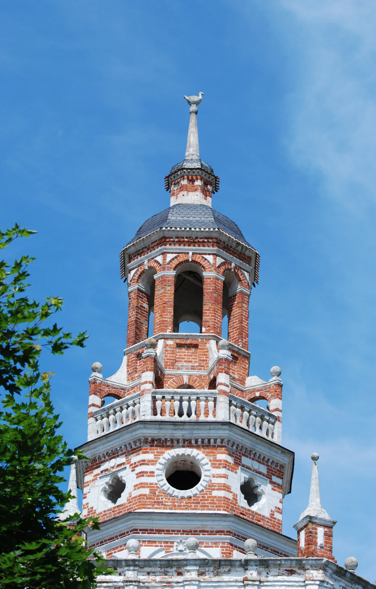 the spire is on top of the large brick building