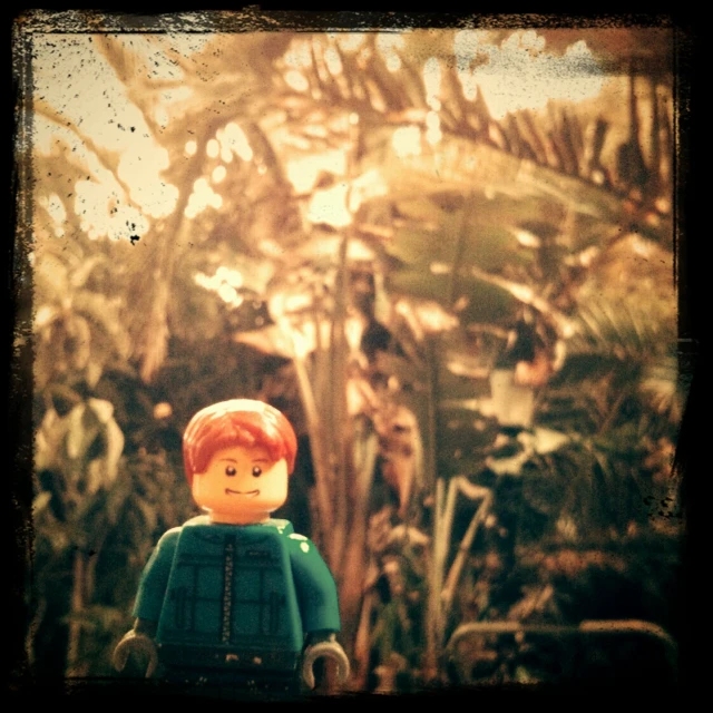 a lego man standing in the middle of some plants