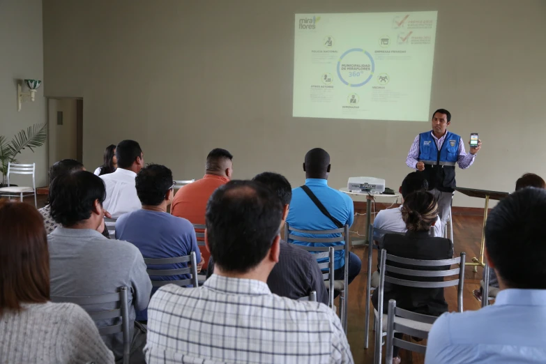 a man stands in front of a class with his colleagues