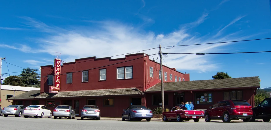 a tall red building with lots of cars parked on the street