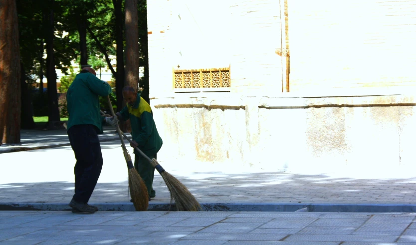 a woman is sweeping out the sidewalk with a mop