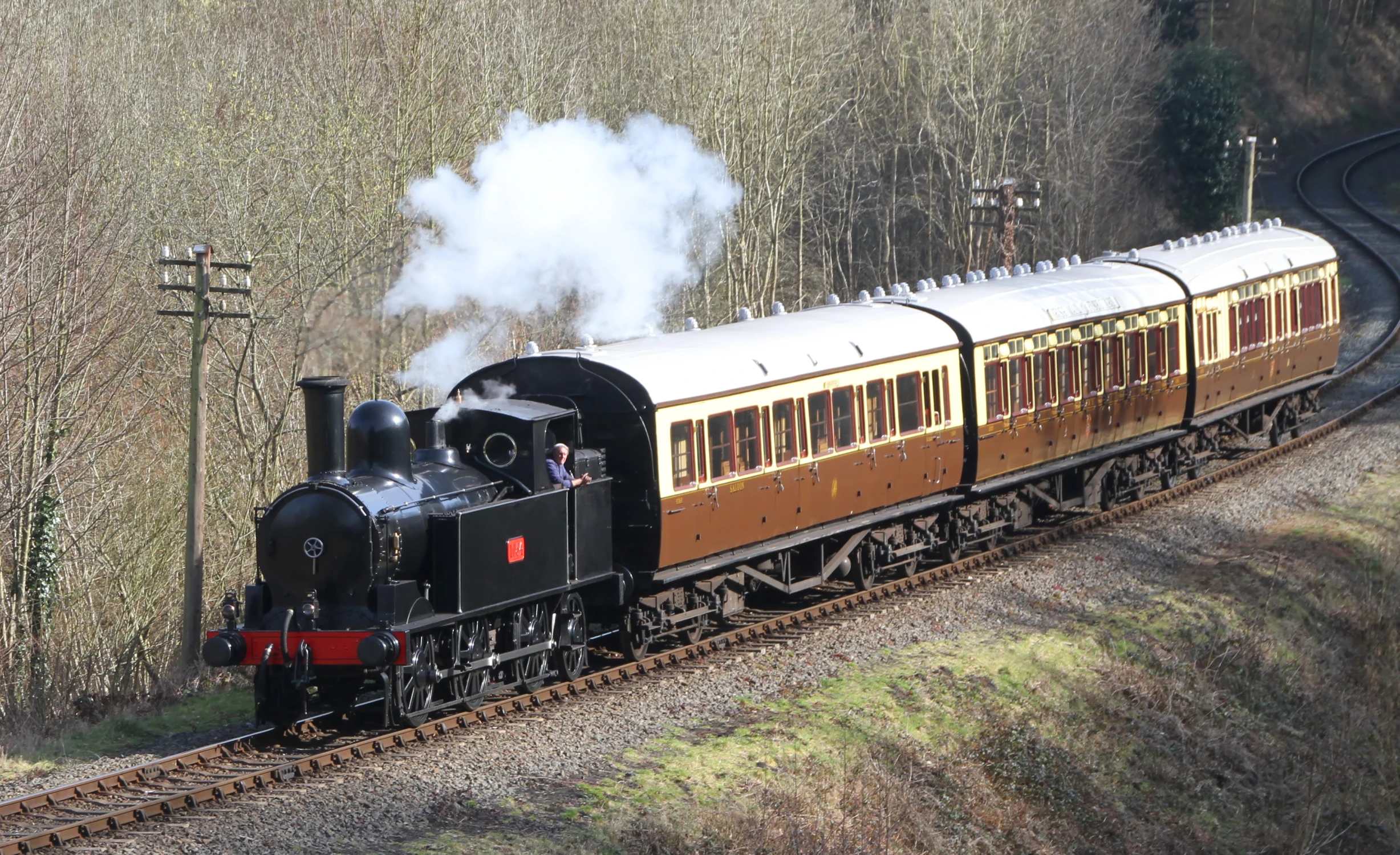 an old steam locomotive on the tracks in the woods