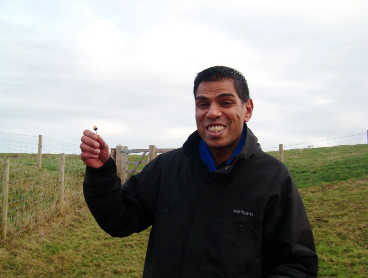 a man is standing in a field and smiling