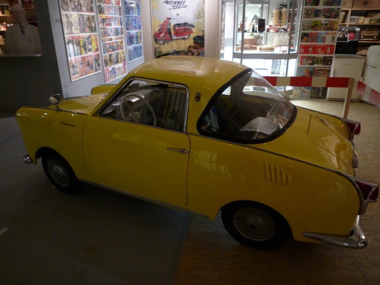 yellow car inside of a store with red and white signs