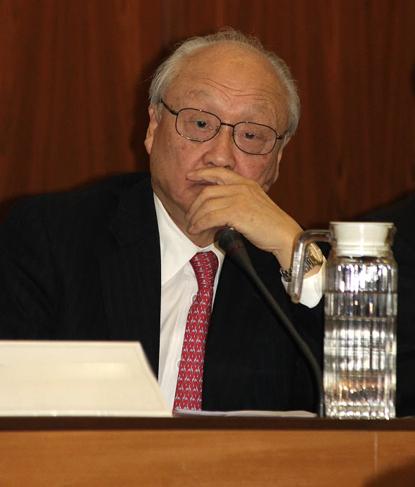 a man in glasses and a tie sits at a table