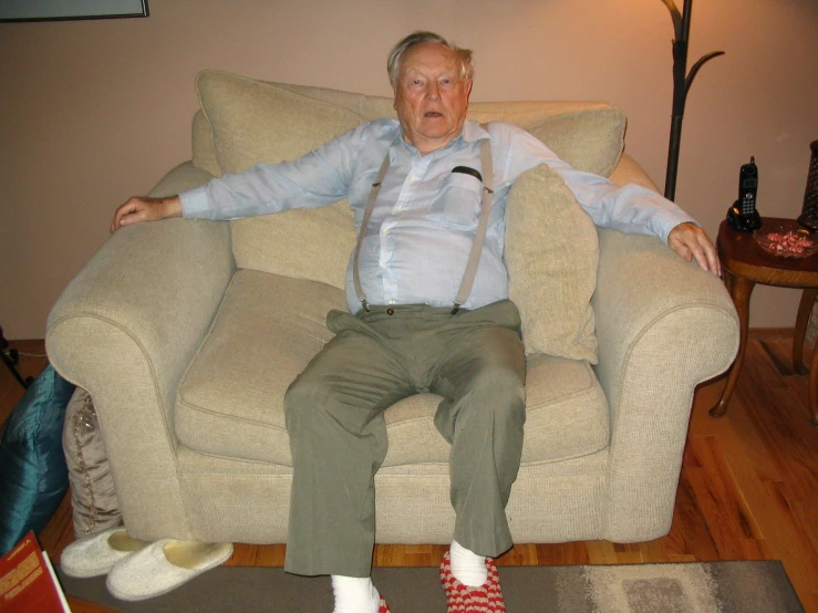 an old man sitting on top of a couch