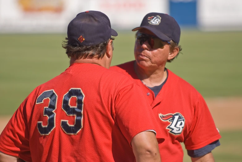 a couple of baseball players standing next to each other on a field