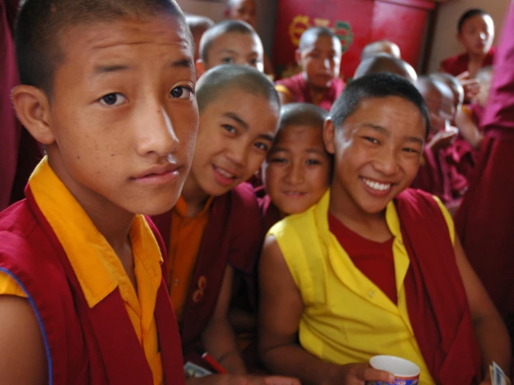 a group of children are standing in front of some cups