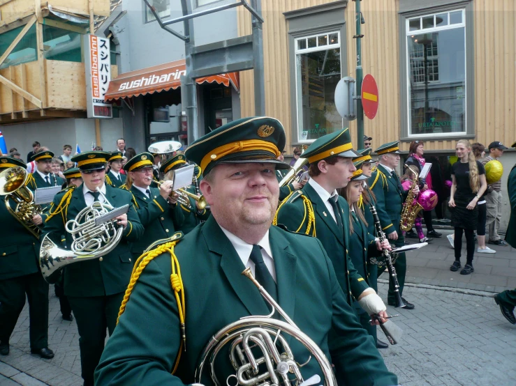 many people wearing green outfits are playing instruments