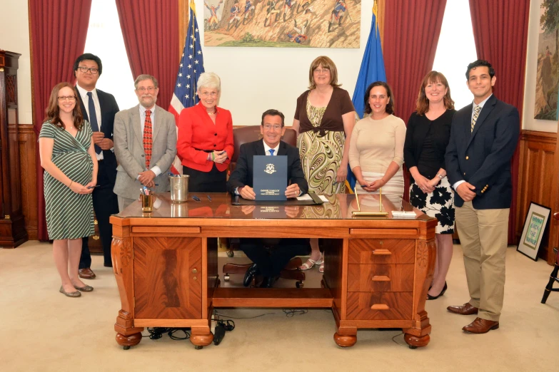 group of people gathered around a wood desk