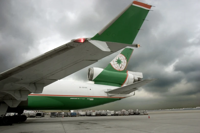 a large green and white airplane parked on the runway