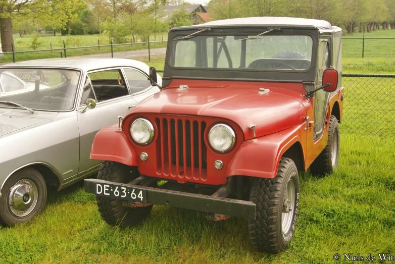 an older style jeep parked next to a newer type jeep