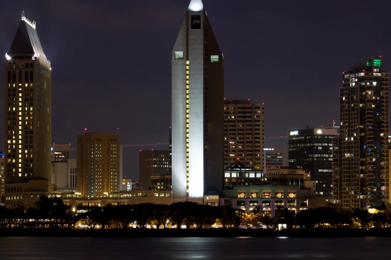 a city with tall buildings and the lights reflecting in the water