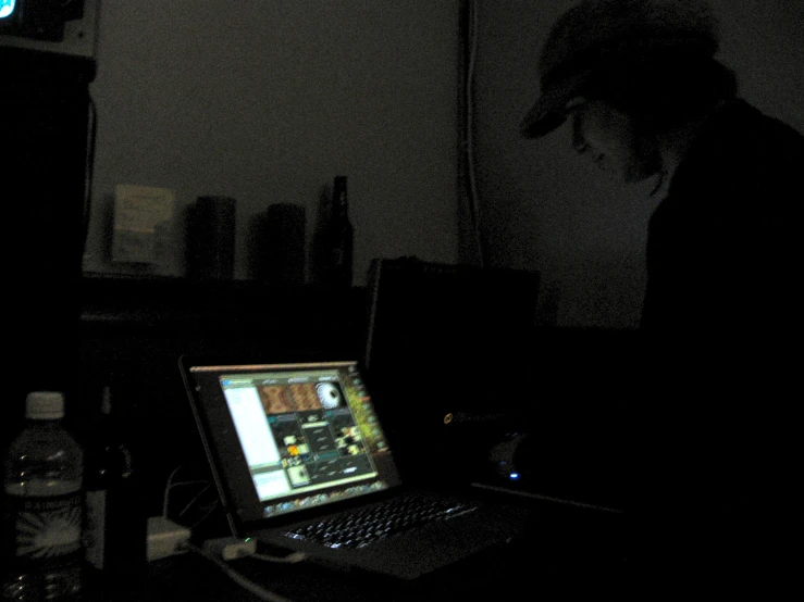 a laptop is lit up on a desk in the dark