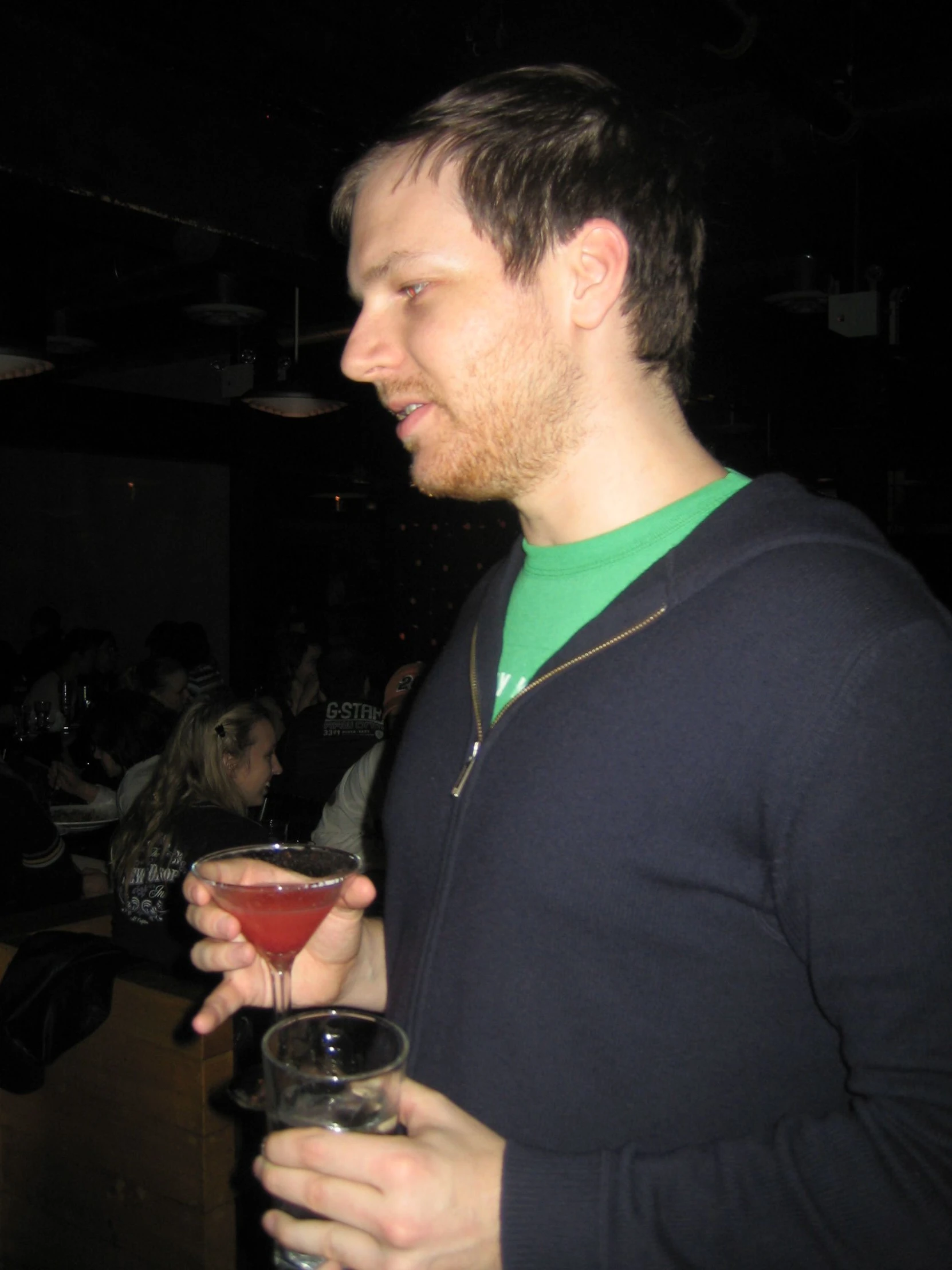 a young man holding up glasses in his hands