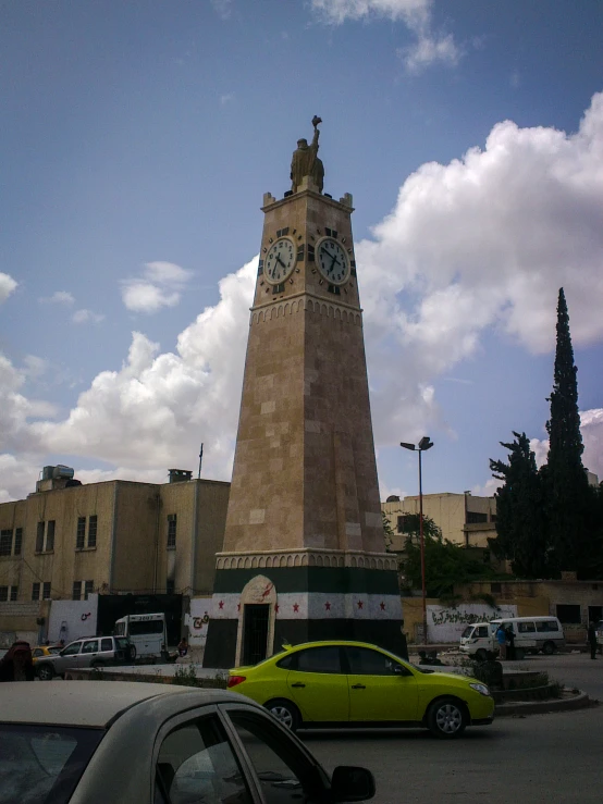 a car is parked in front of a tower clock