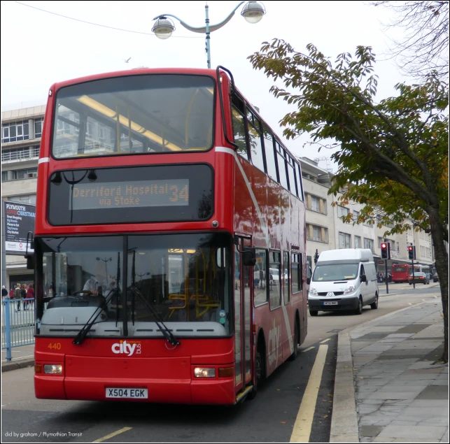 a red double decker bus traveling down the street