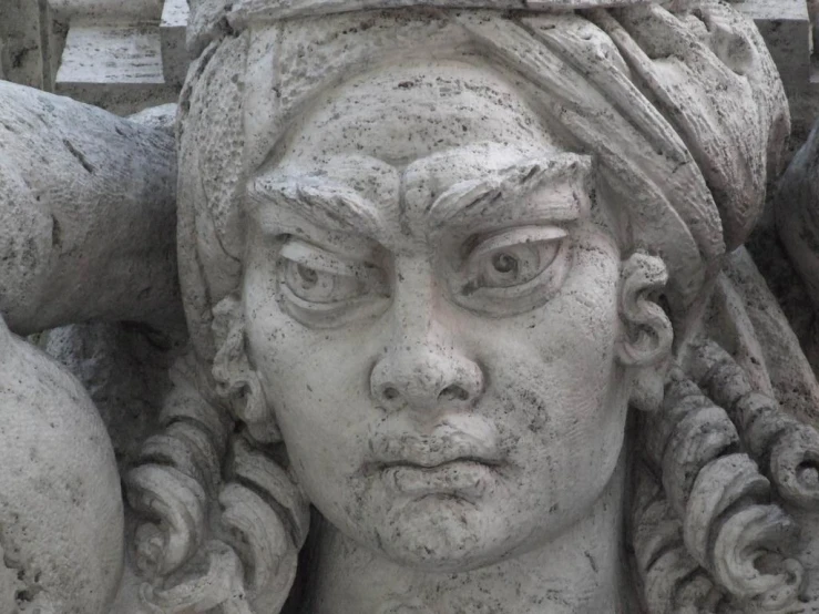 an outdoor statue of a girl wearing wreaths