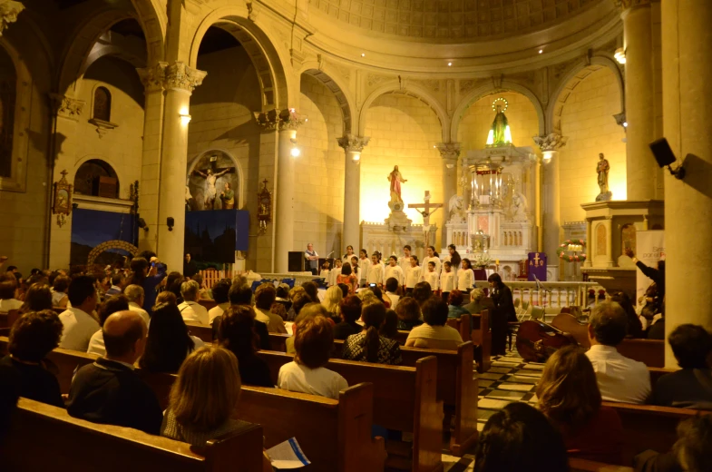 people sitting in pews in a church while one person walks by