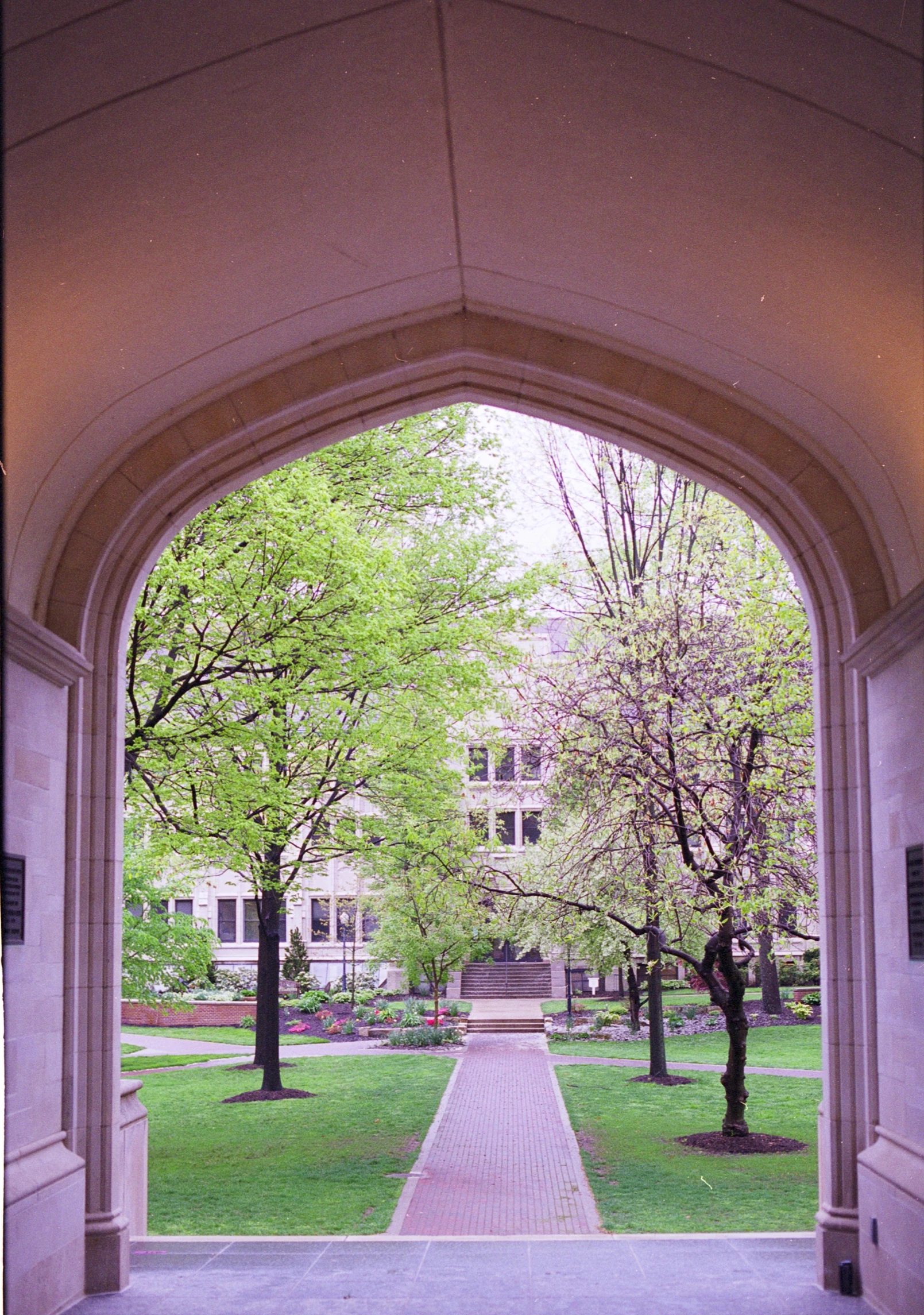 a walkway through an archway leading to an office building