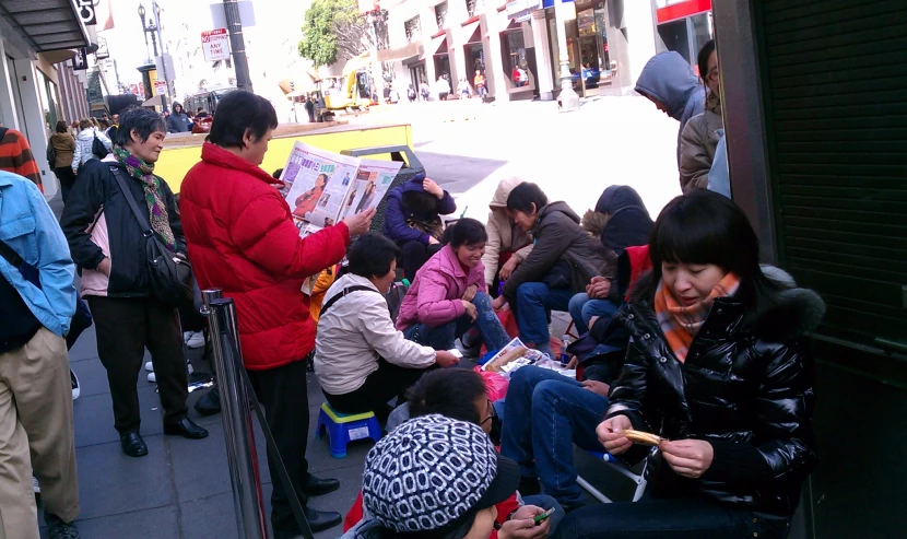 people on a city street reading newspapers and waiting for the next bus