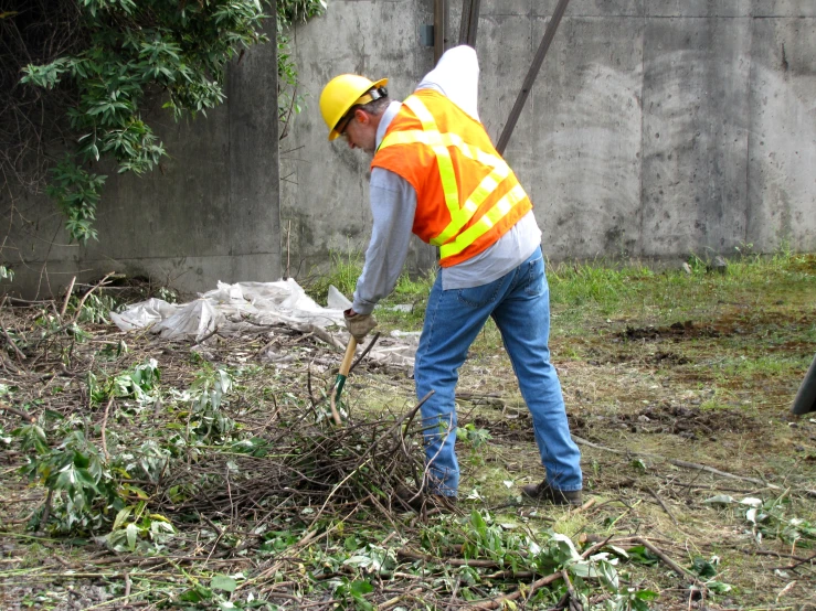 a person standing in a field and wearing a hard hat