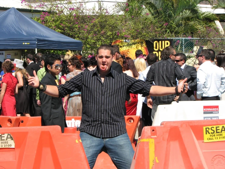 a guy standing with his hands open with others around him