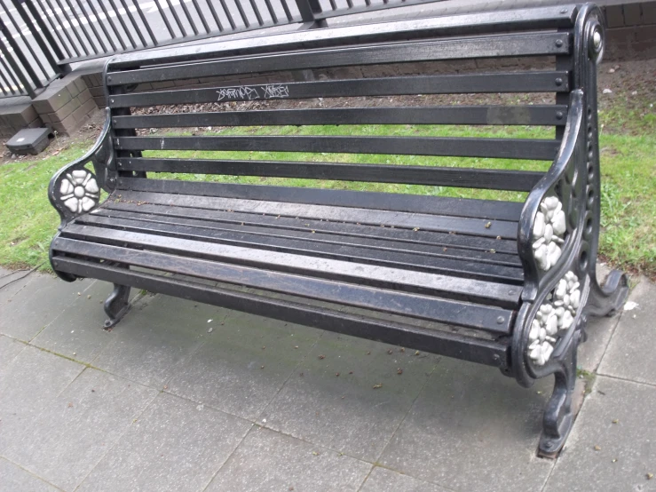 a bench on a city street next to a fence