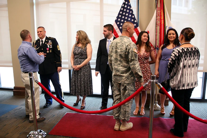 a group of people standing next to each other near flags