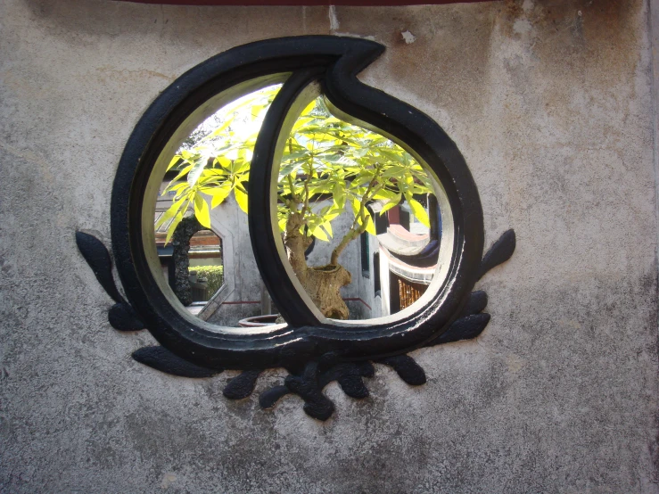 a mirror image looking at an abstract, ornate design on a wall
