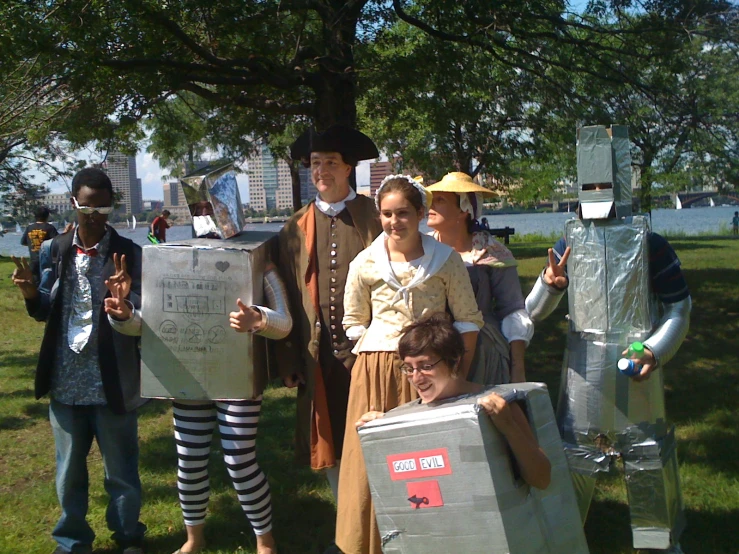 four people posing in costumes holding paper bags and wearing paper cutouts